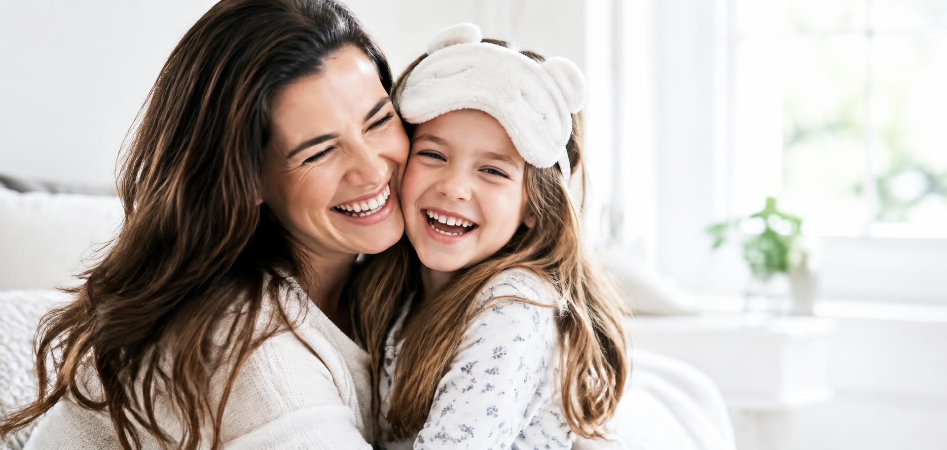 A joyful mother and daughter embracing and laughing together